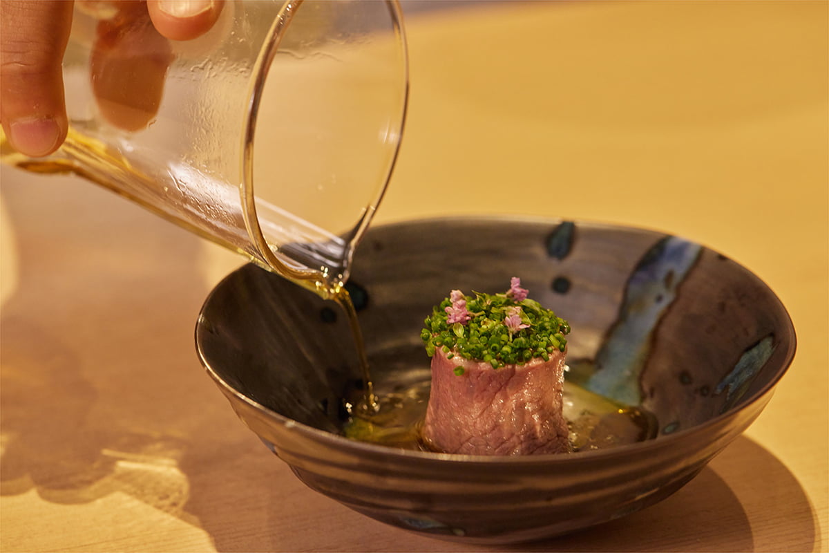 焼きなすを熟成させて炙った牛肉で巻き円柱状にし細かく刻んだねぎやみょうがを添えた一品