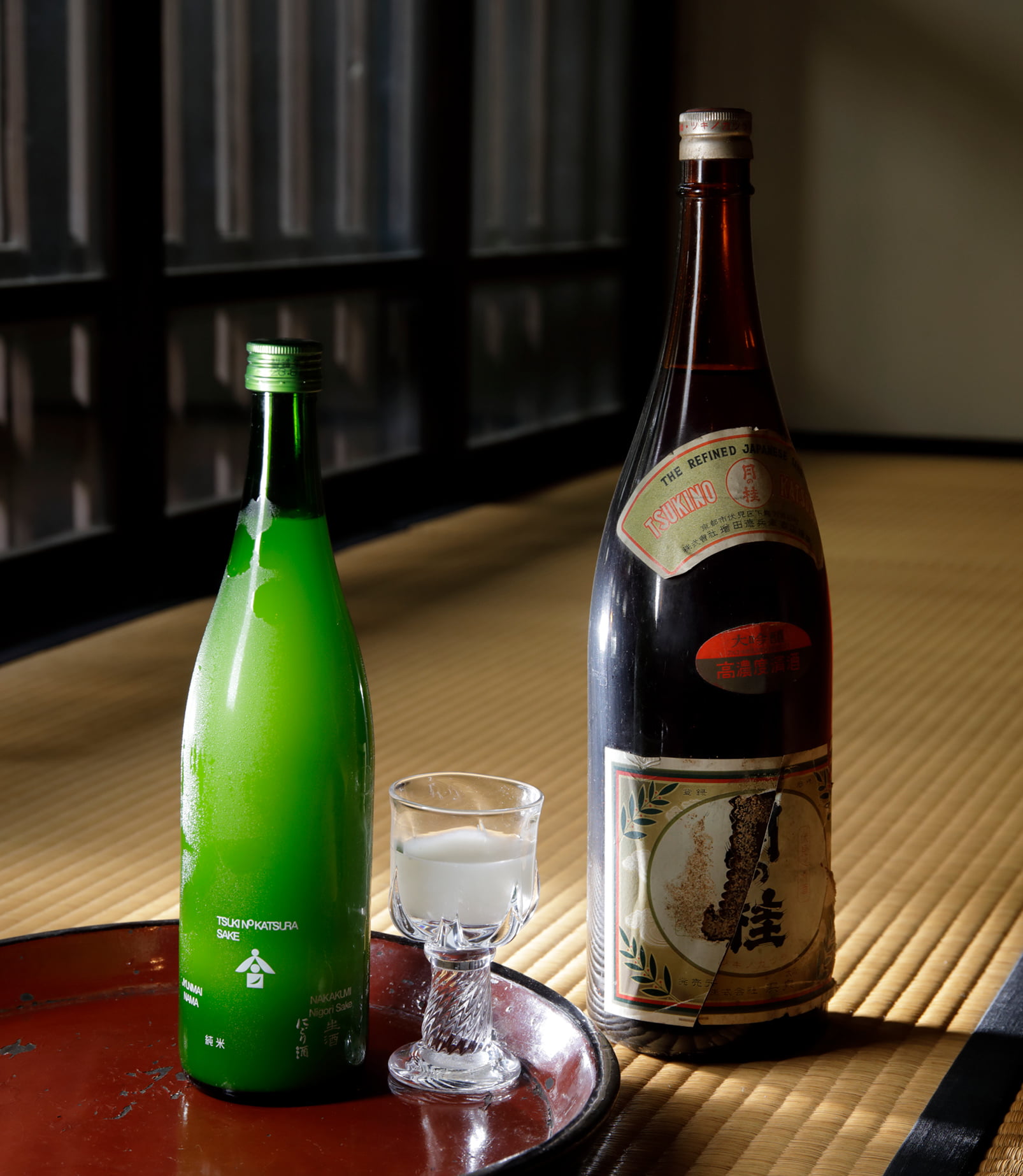 月の桂の代名詞として親しまれている「純米にごり酒」。右の一升瓶は1964年の発売当時のもの。シュワシュワっとした泡が心地よいスパークリングにごり酒で、立ち上る気泡が目で楽しめるよう醇一社長がラベルデザインを一新した。