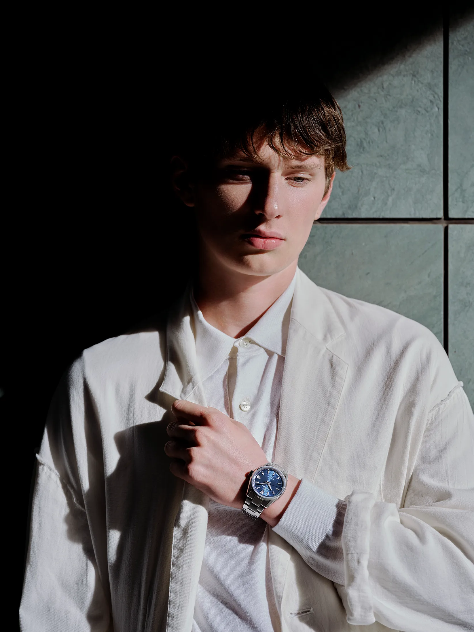 A visual capturing a model wearing the GRAND SEIKO watch SLGB013, with the theme of LIGHT & SHADOW.