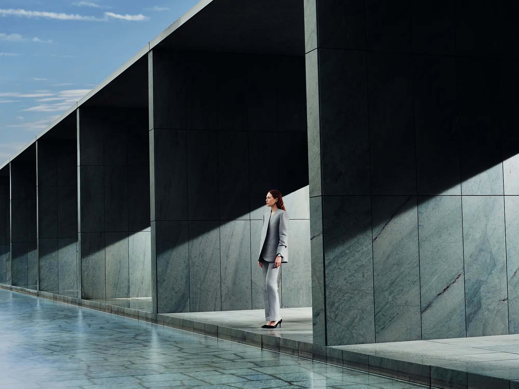 A visual featuring a model wearing the GRAND SEIKO watch SLGB013 in front of famous architecture, themed around LIGHT & SHADOW.