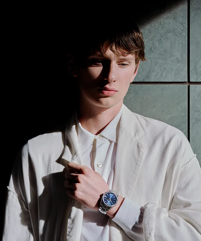 A visual featuring a model wearing the Grand Seiko watch SLGB013, themed around Light & Shadow.